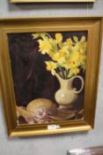 A GILT FRAMED OIL ON BOARD OF A STILL LIFE STUDY OF DAFFODILS IN A JUG, MARKED LEO FISON BATES