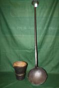 A LARGE CAST IRON LADLE, L 108 cm, together with a cast iron smelting pot, H 21 cm (2)