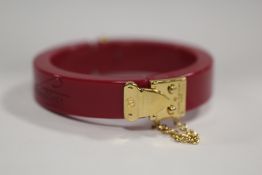LOUIS VUITTON - A RESIN 'LOCK ME' HINGED BANGLE, with original box and Louis Vuitton drawstring bag