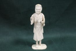 A JAPANESE CARVED IVORY OKIMONO, depicting an artist / scholar, the right hand with a missing