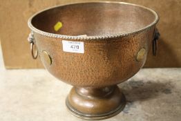 AN UNUSUAL HAMMERED FINISH COPPER TWIN HANDLED FOOTED BOWL WITH GEORGIAN COINS TO OUTER EDGE,