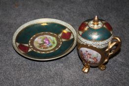 A CONTINENTAL STYLE FIGURATIVE CUP AND SAUCER WITH COVER