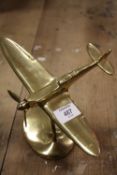 A BRASS MODEL OF A PLANE IN FLIGHT