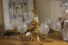 A BRASS EFFECT EIGHT BRANCH CHANDELIER WITH GLASS SHADES