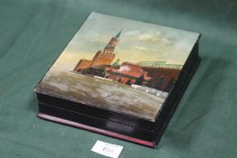 A VINTAGE HAND PAINTED LACQUERWARE LIDDED BOX DEPICTING RUSSIAN BUILDINGS, TOGETHER WITH A SILVER
