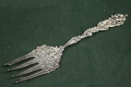 AN ORNATE STERLING SILVER SERVING FORK BY MARSHAL FIELD & CO