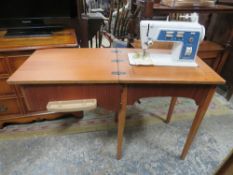 A SINGER ELECTRIC SEWING MACHINE IN TABLE