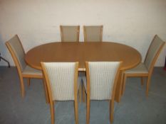 A SKOVBY EXTENDING OVAL DINING TABLE AND SIX CHAIRS