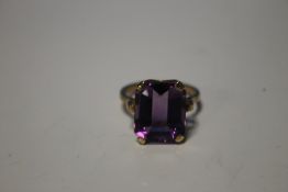 A 9 CT GOLD DRESS RING SET WITH LARGE PURPLE STONE