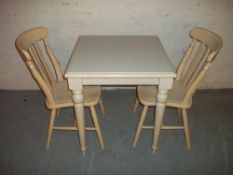 A MODERN DINING TABLE WITH TWO CHAIRS