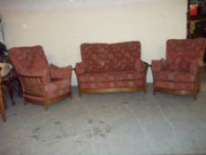 AN OAK ERCOL THREE PIECE SUITE, CONSISTING OF A TWO SEATER SOFA AND TWO CHAIRS