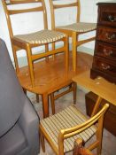 A MODERN DINING TABLE AND FOUR CHAIRS