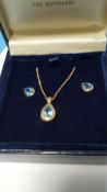 A 9 CT GOLD AND BLUE STONE SET PENDANT WITH MATCHING EARRINGS