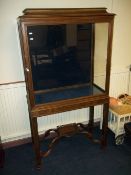 A CHIPPENDALE STYLE DISPLAY CABINET ON LEGS WITH CARVED DETAILING