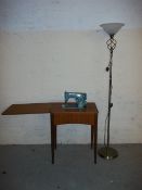 A SINGER SEWING MACHINE AND TABLE WITH A FLOOR STANDING LAMP