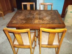 AN EARLY 1900S DRAW LEAF OAK DINING TABLE WITH FOUR CHAIRS