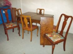 A WALNUT EXTENDING DINING TABLE WITH FOUR CHAIRS TOGETHER WITH TWO MATCHED CHAIRS ALL WITH