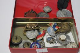 A SMALL TIN OF COLLECTABLES TO INCLUDE MEDALS, BADGES AND WATCH MOVEMENTS