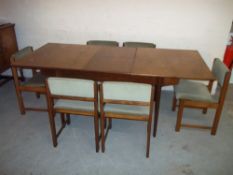 A RETRO TEAK EXTENDING DINING TABLE AND SIX SWIVEL BACKED DINING CHAIRS