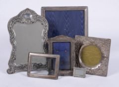 A collection of silver mounted photo frames and a silver mounted mirror