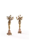 A pair of French gilt metal and marble mounted five light figural candelabra