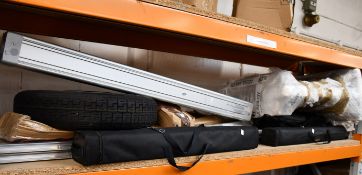 A shelf of miscellaneous items to include Festool, a wheel, photo stands and metal curb ramps.