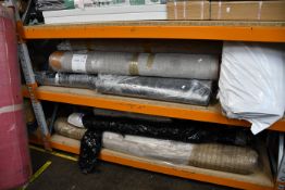 Two shelves of carpets, rugs and foam floor mats.