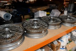 A set of four pre-owned vintage spoke car wheels.