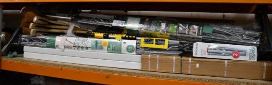 A shelf of miscellaneous items to include washing lines, brushes and curtains.