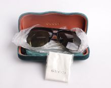 A pair of as new cased Gucci sunglasses.