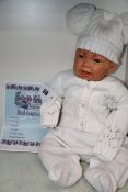 One as new Butterfly Babies reborn boy/girl baby doll in white cardigan and bobble hat.