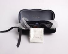 A pair of as new cased Gucci sunglasses.