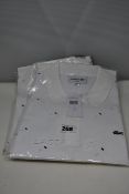 Three as new Lacoste white polo shirts with blue decoration (US S, M, L).