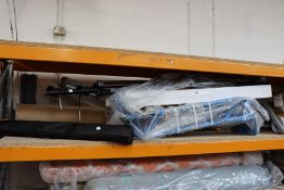 A shelf of miscellaneous items to include tripod stands and sack trucks.