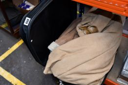 A suitcase containing fur and other coats.