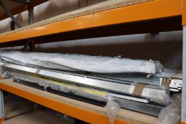 A shelf of miscellaneous items to include plastic tubing and metal support brackets.