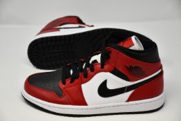 A pair of Nike Air Jordan 1 mid trainers (UK 7).
