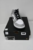 A pair of as new Nike Air Jordan 1 mid GS trainers (UK 4).
