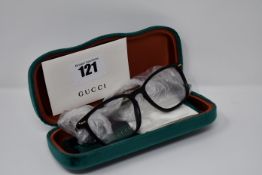 A pair of as new Gucci glasses frames with clear glass.