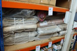 One shelf of various rugs, matts and related items.