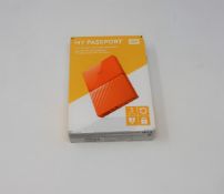A boxed as new WD My Passport 3TB Portable Hard Drive in Orange (Some cosmetic damage to box).