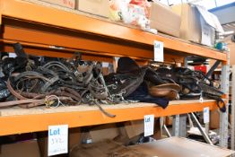 A quantity of pre-owned saddles and tack to include bridles and bits.