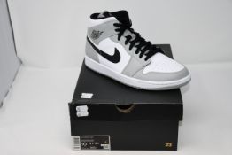 A pair of as new Nike Air Jordan 1 mid trainers (UK 9).