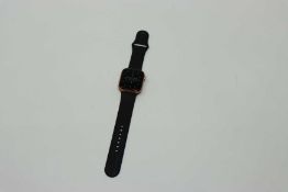 A pre-owned Apple Watch Series 5 GPS Aluminum 44mm in Gold (Serial: FH7ZM05CMLTP) with a M/L Black