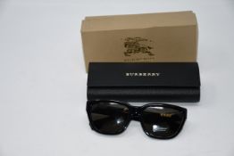 A pair of Burberry sunglasses with case and box.