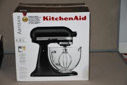One boxed KitchenAid Artisan 4.8L stand mixer in matte black (5KSM156BBM).