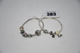 Two Pandora bracelets with six charms.