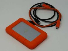 A pre-owned LaCie Rugged USB-C Portable Hard Drive 2TB Orange with two cables.