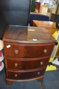 Three Drawer Mahogany Effect Glass Topped Bow Fron