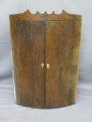 ANTIQUE OAK BOW FRONT TWO DOOR WALL HANGING CORNER CUPBOARD with interior shelves and shaped top